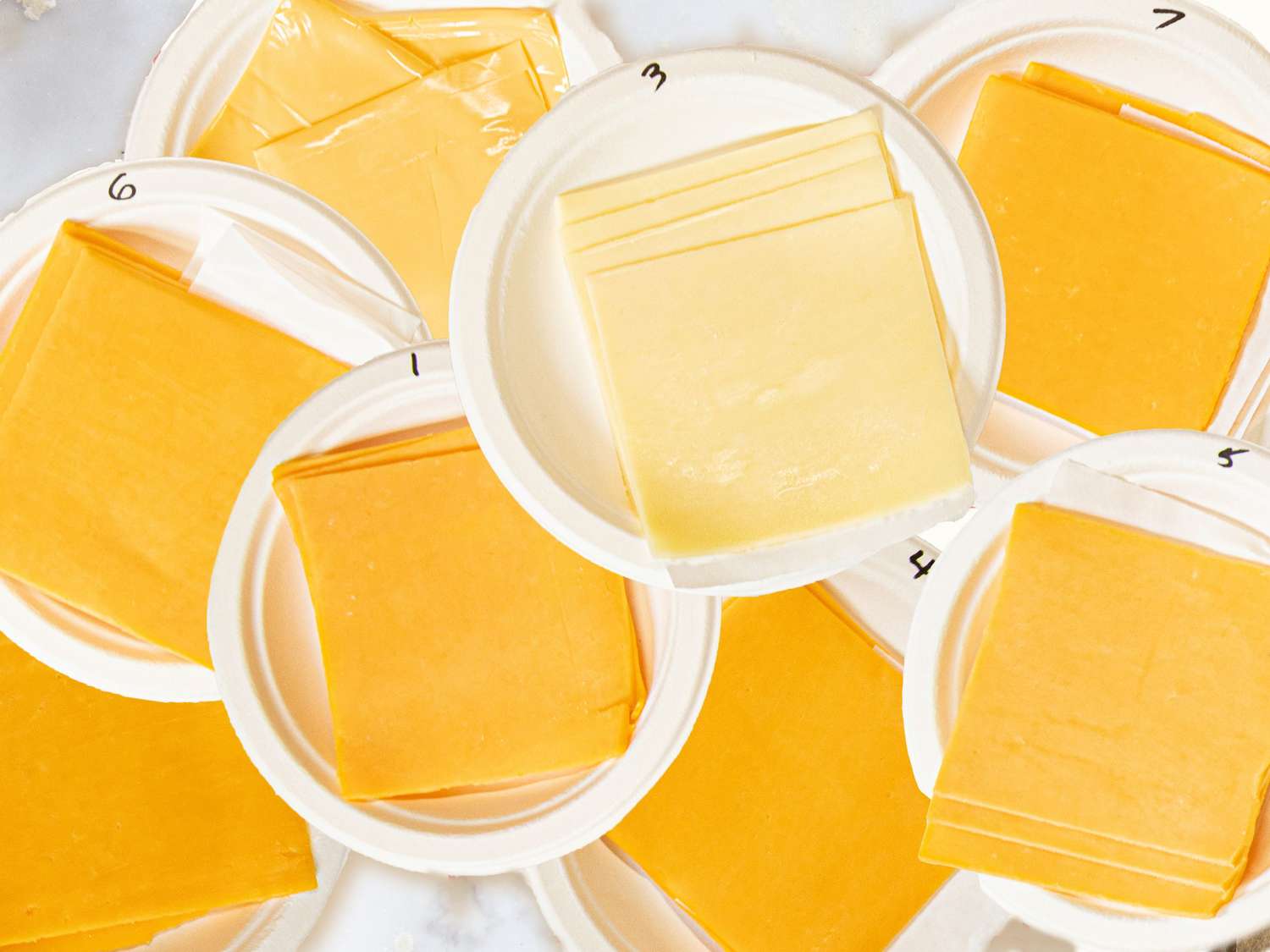 Slices of cheese on paper plates.