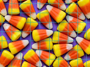 Pattern of candy corn on a purple grid background