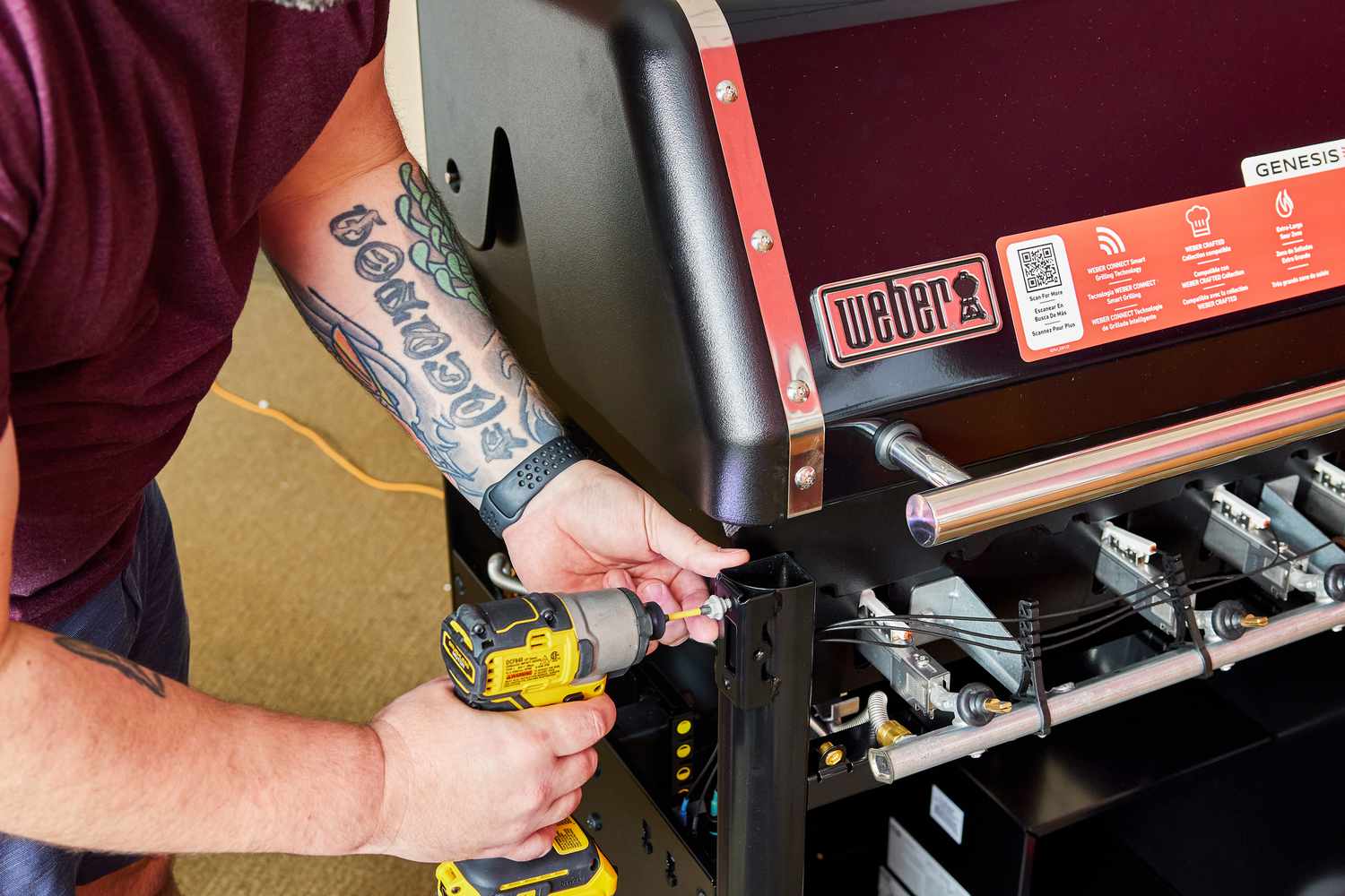Hands using a drill to assemble Weber Genesis E-325s 3-Burner Gas Grill