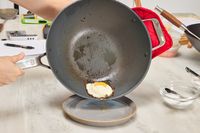 An egg cooked in the Misen 12 Inch Carbon Steel Wok is placed on a plate