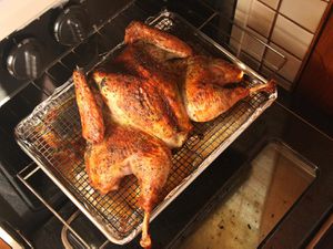 Herb-Rubbed Crisp-Skinned Butterflied Roast Turkey on a rack in the oven.