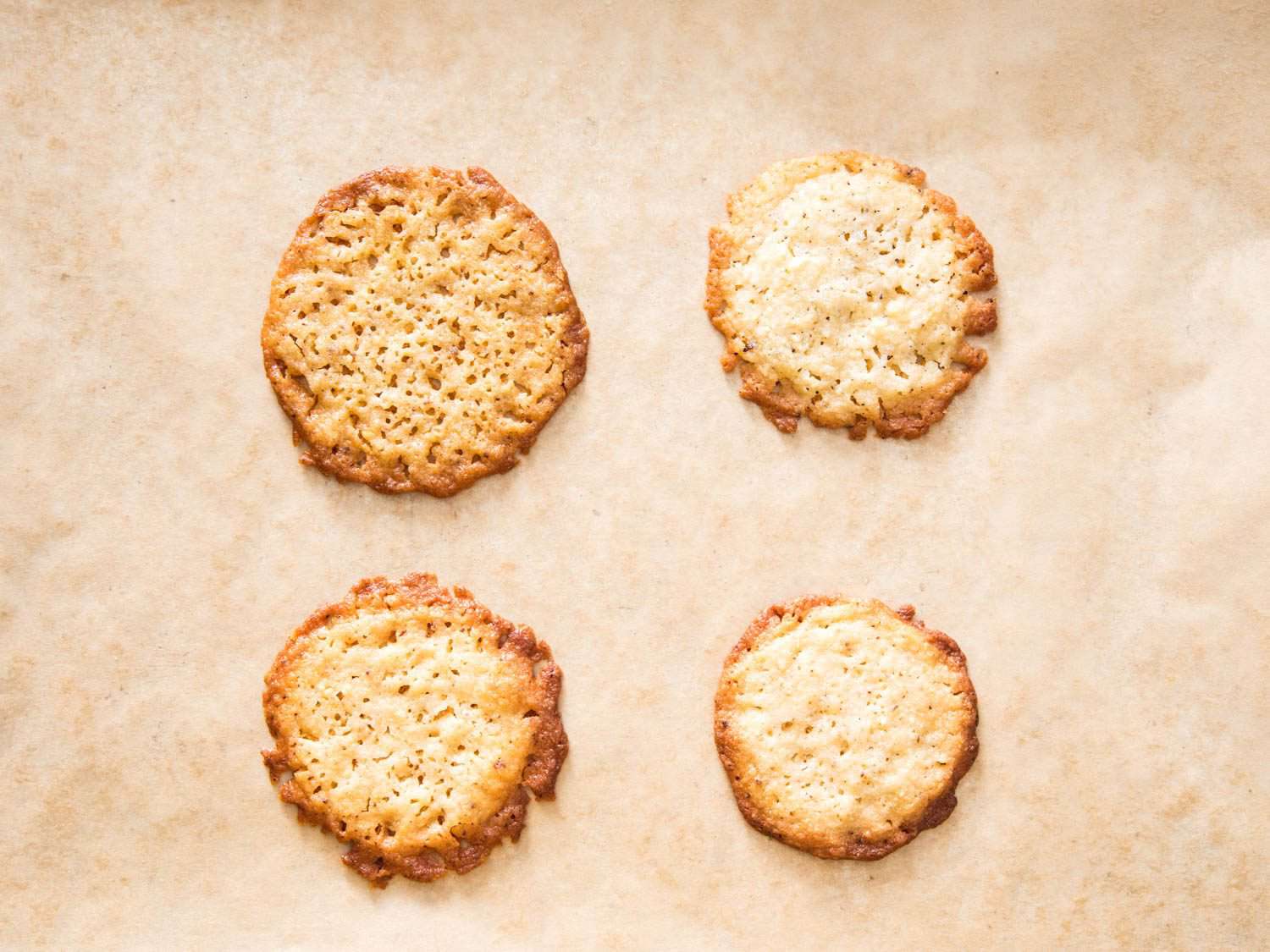 Overhead view of four ricotta-brown butter cookies made with different types of ricotta, to illustrate how different ricotta will affect final product.
