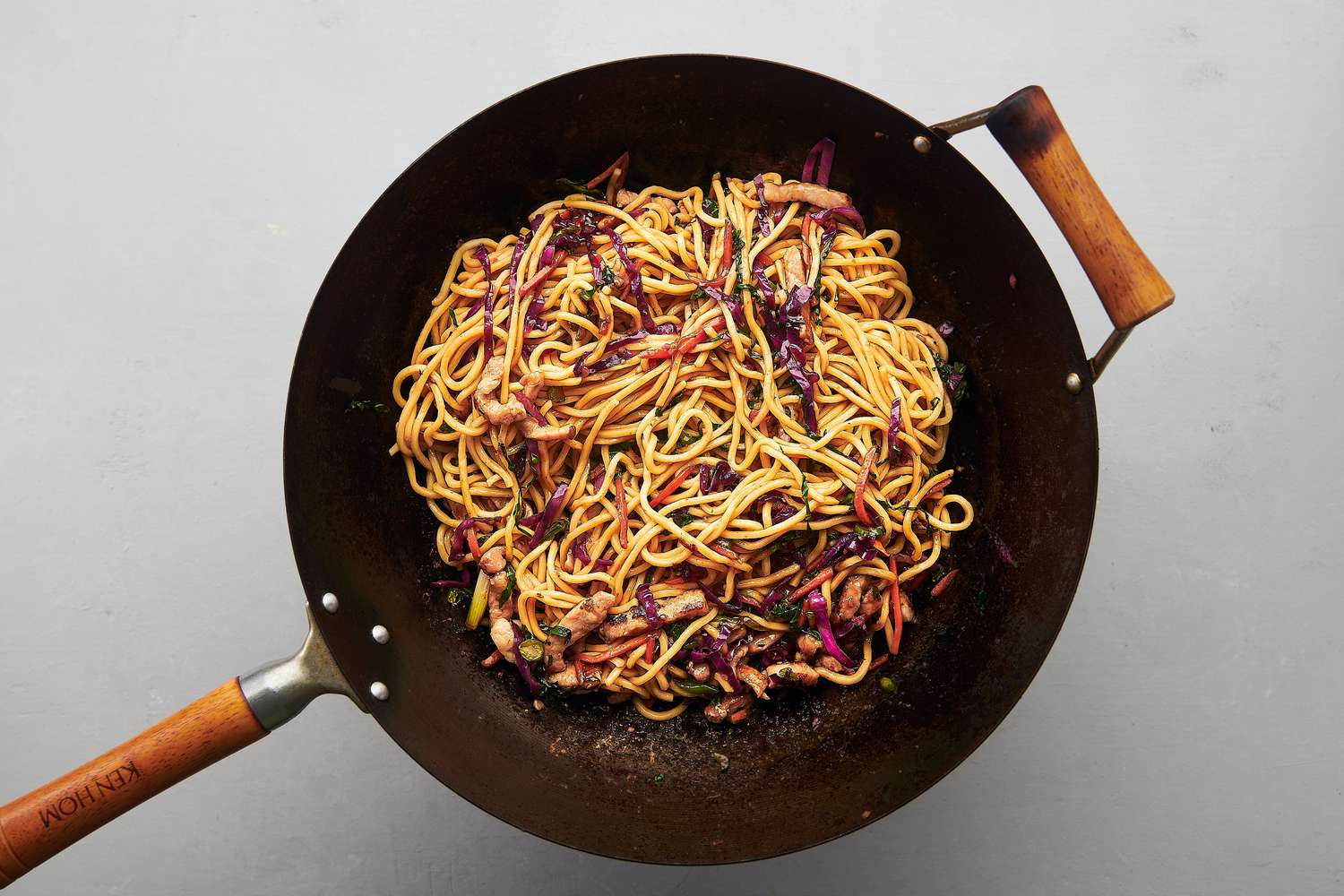 Remaining sauce, vegetables, and pork tossed well with noodles inside wok over heat 