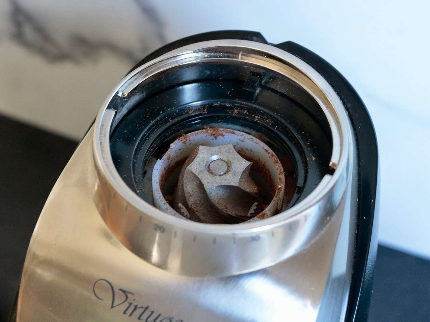 a close up of an open coffee grinder showing off the burr set inside