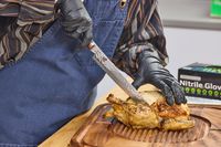A person slices chicken with the Miyabi Mizu SG2 9.5 Inch Slicing Knife