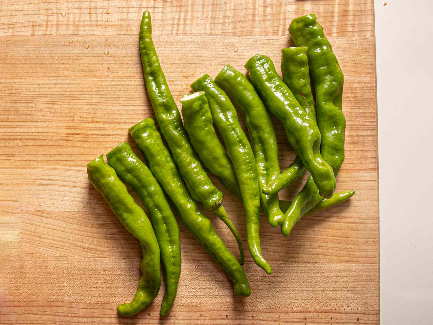 Green chiles on a work surface, stems removed