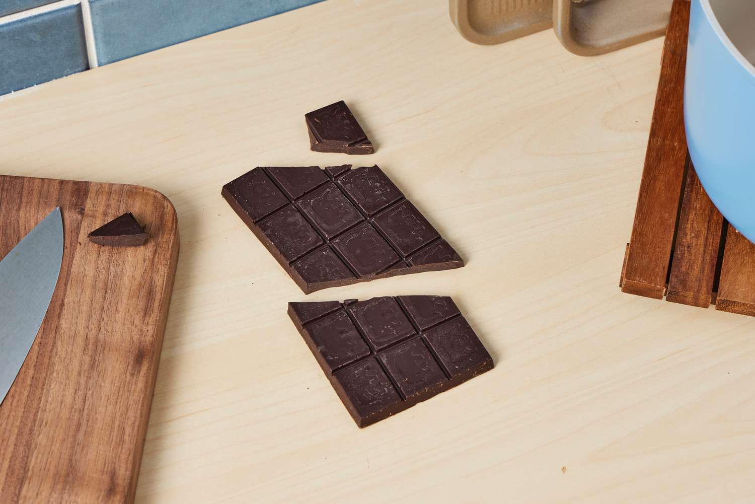 An unwrapped dark chocolate bar on a kitchen countertop.