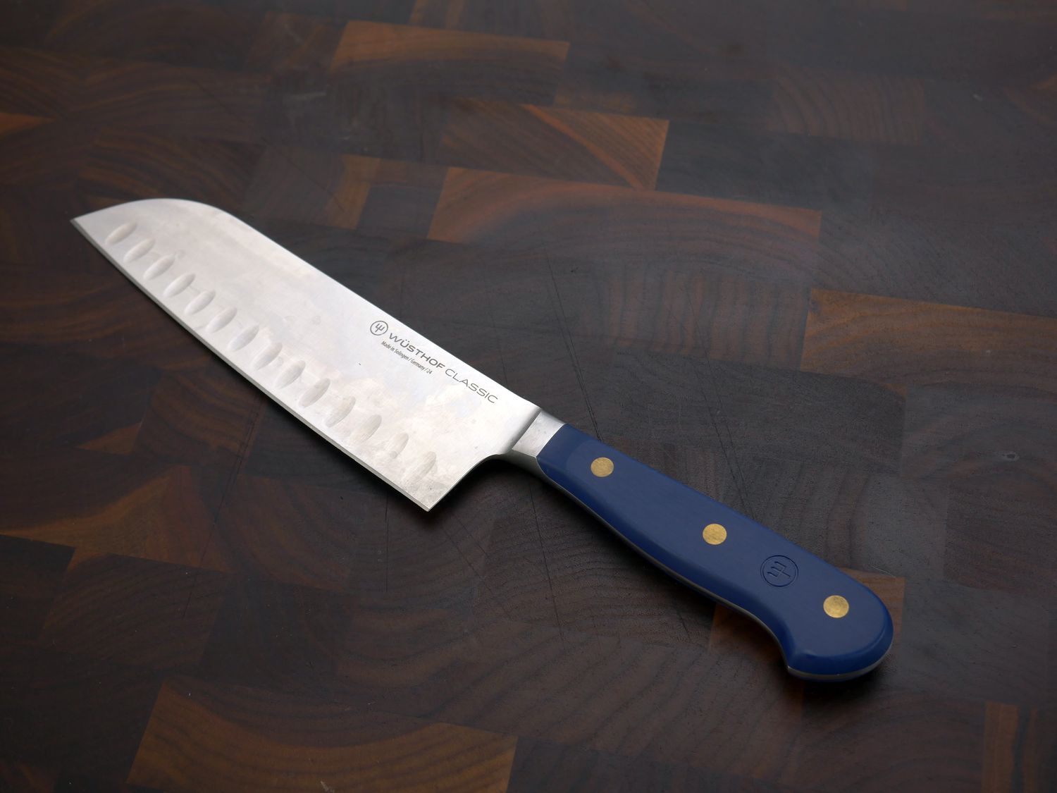 wusthof santoku on a dark wood surface