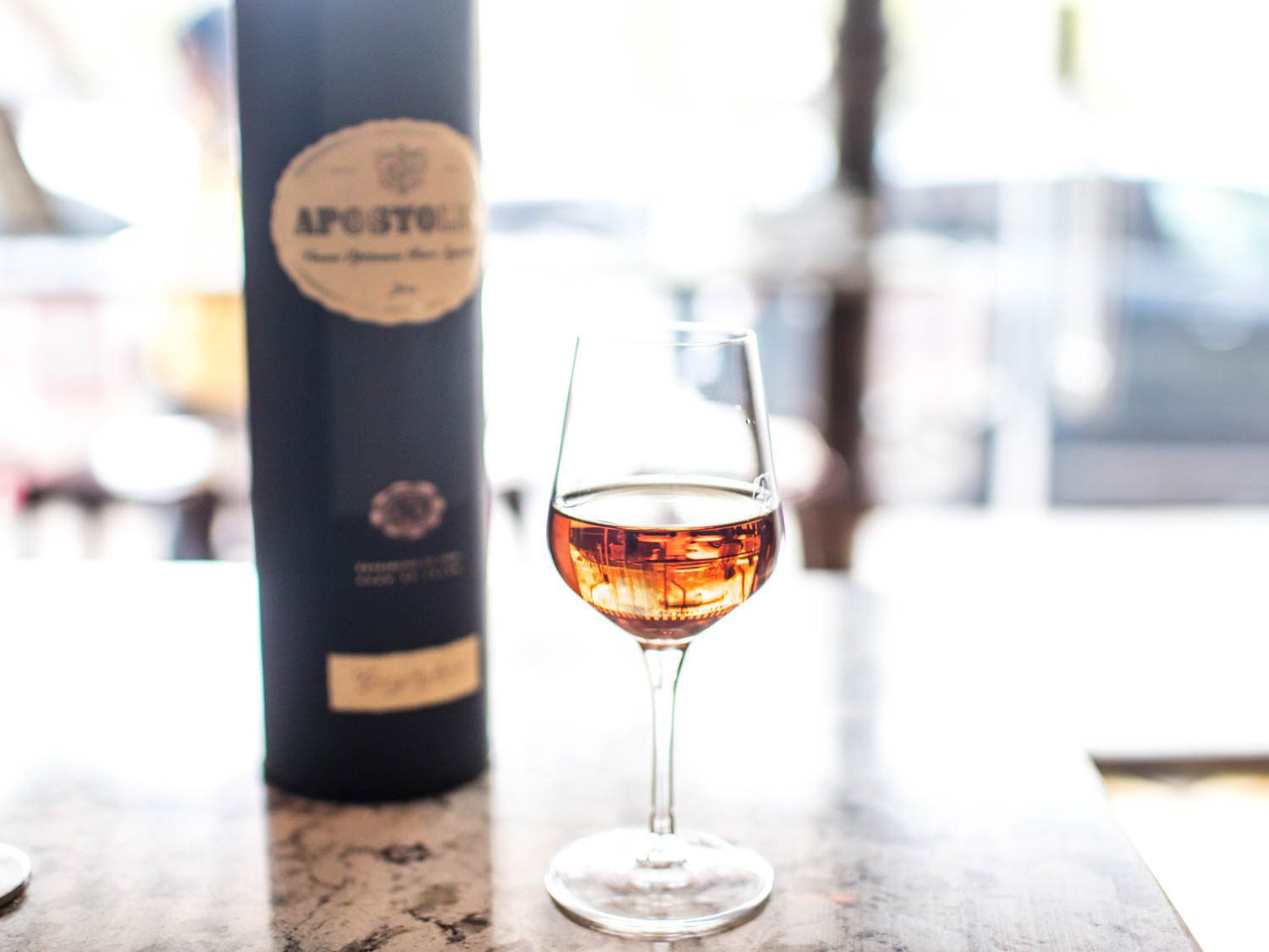 A wineglass of amber Palo Cortado sherry, with a bottle in the background