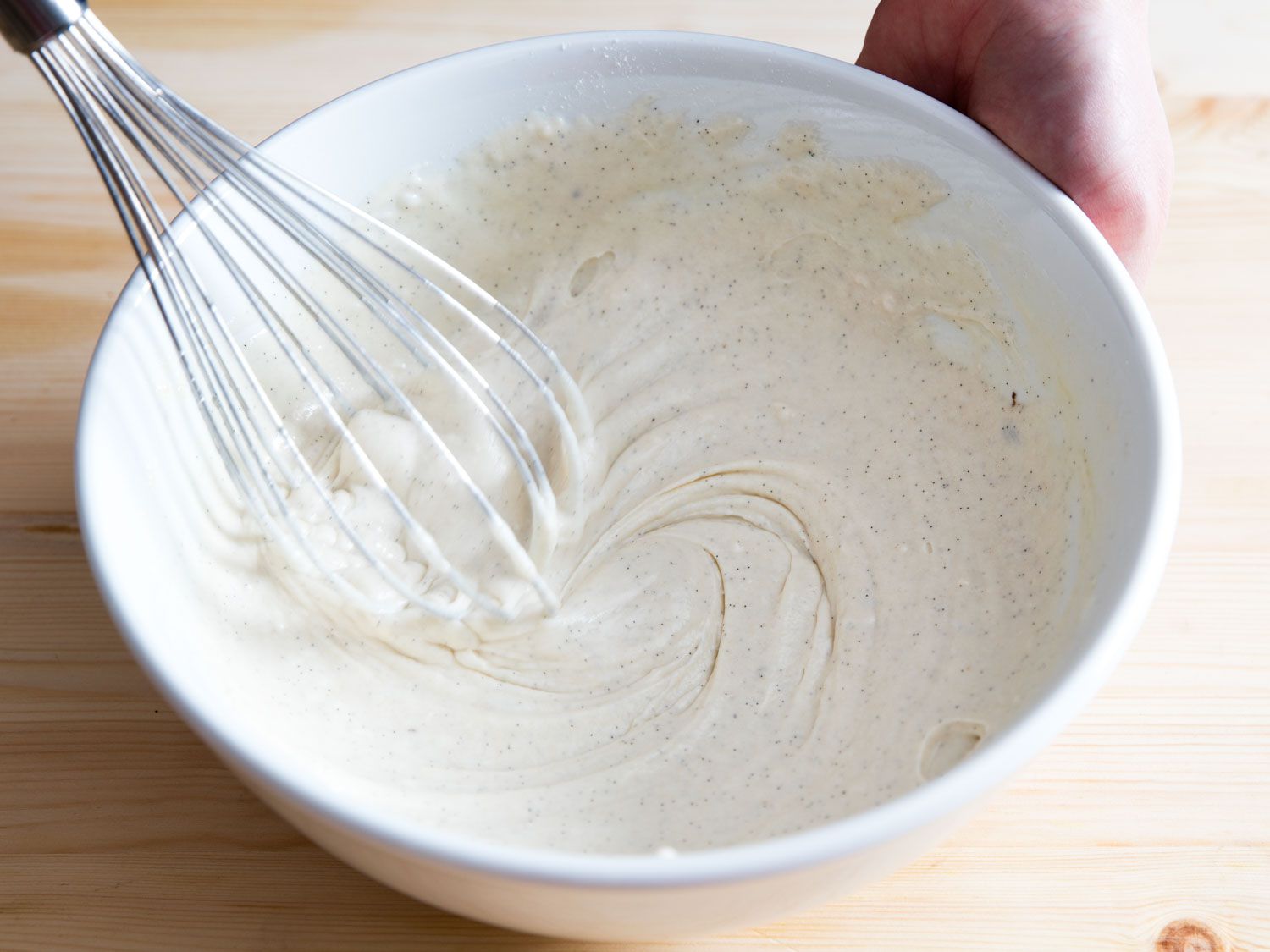Whisking ingredients until combined for waffle batter.