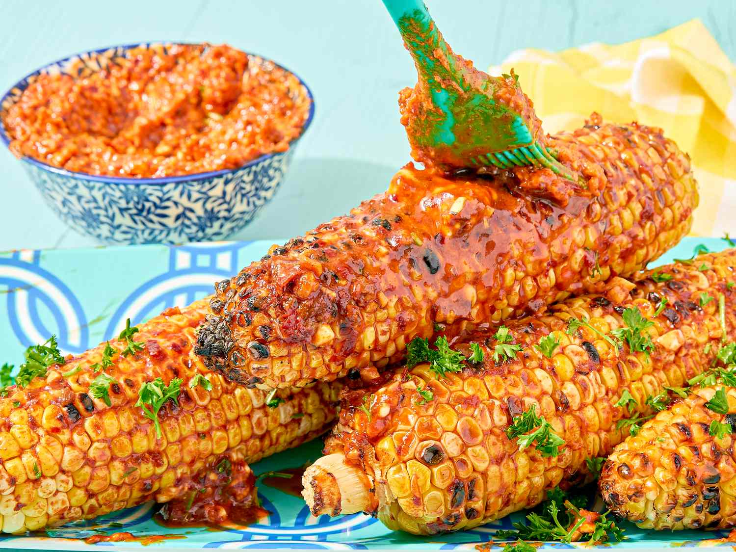 Grilled corn on the cob brushed with paprika and harissa butter