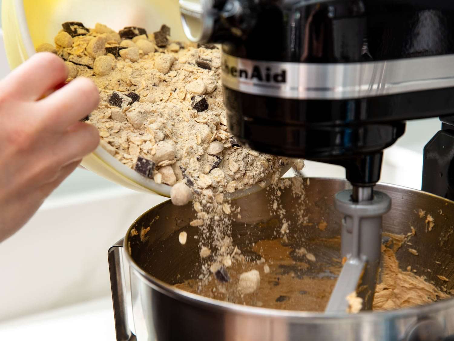 Adding the prepared dry mix to the cookie dough as it is creamed on a stand mixer fitted with a paddle attachment.