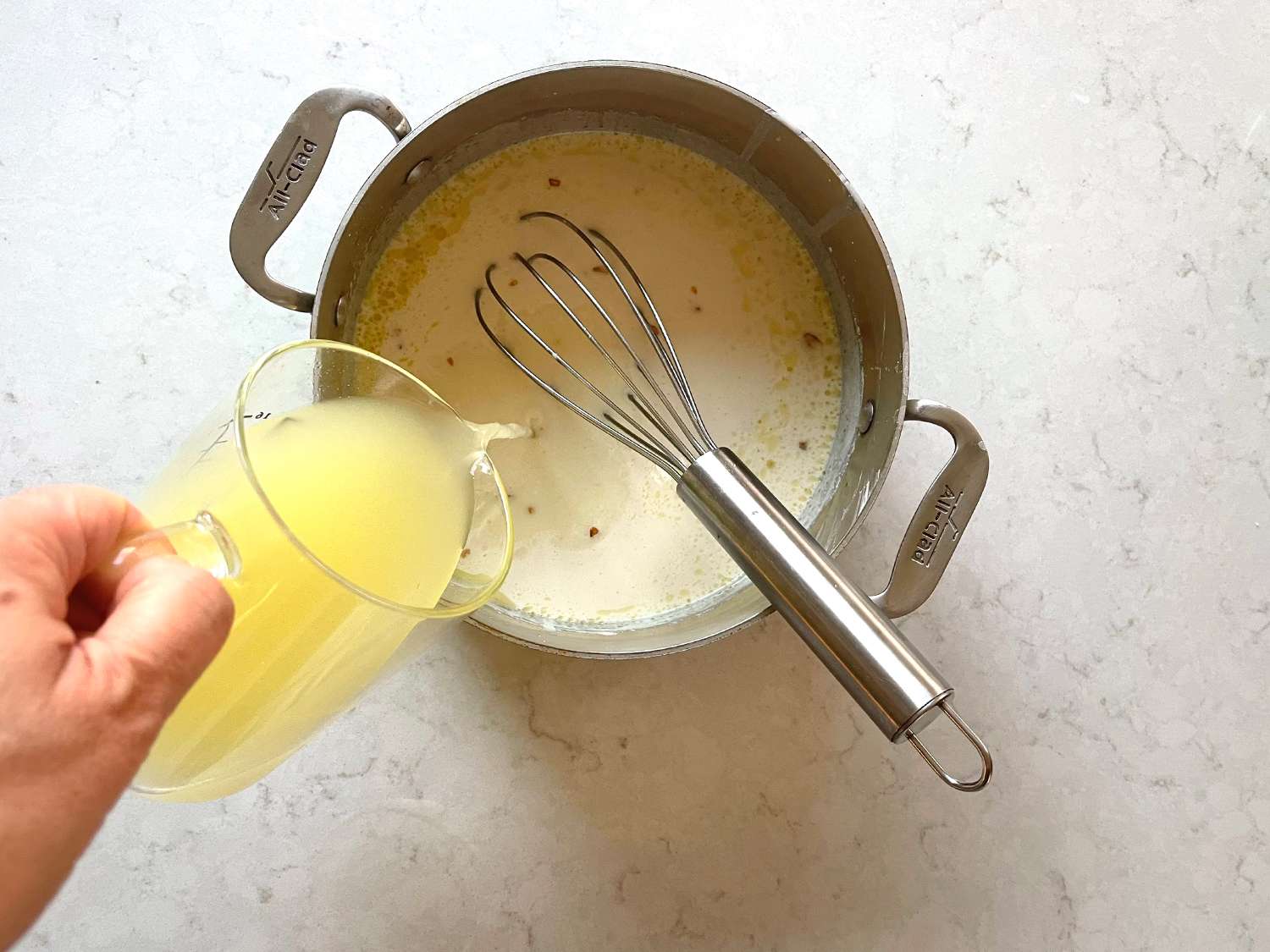 Overhead view of pouring broth into yogurt