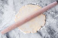 A J.K. Adams Maple French Rolling Pin on rolledout dough on a floured surface