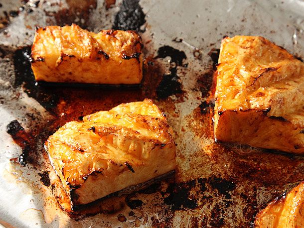 Large roasted chunks of fresh pineapple on aluminum foil