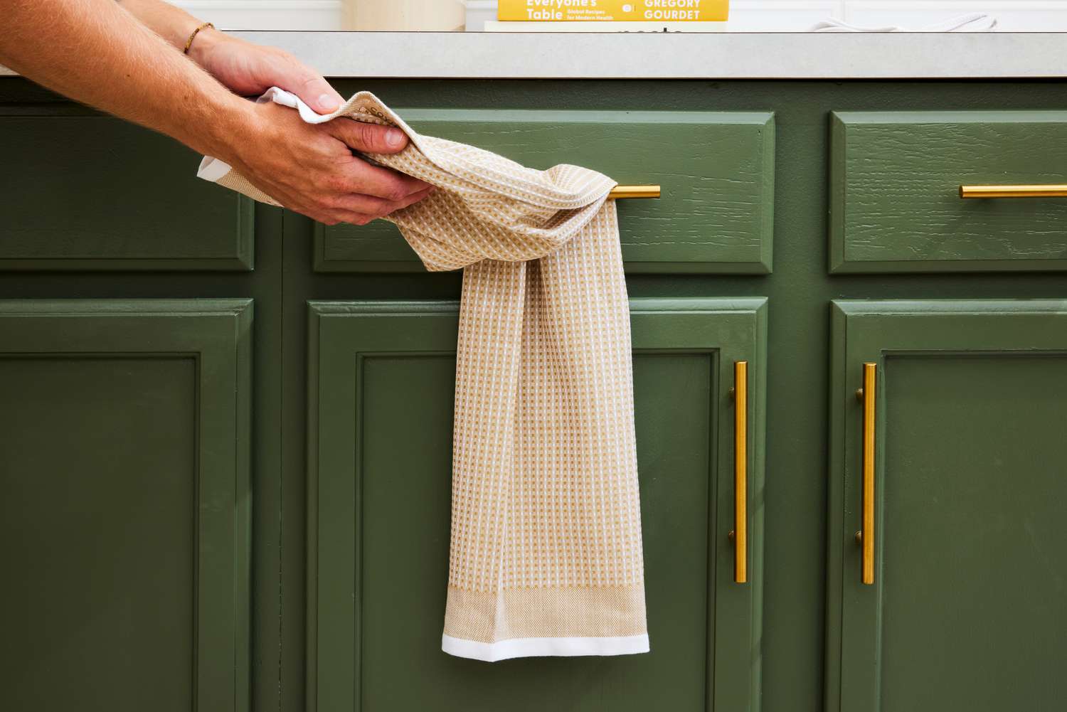 A person drying their hands on a waffle weave dish towel.