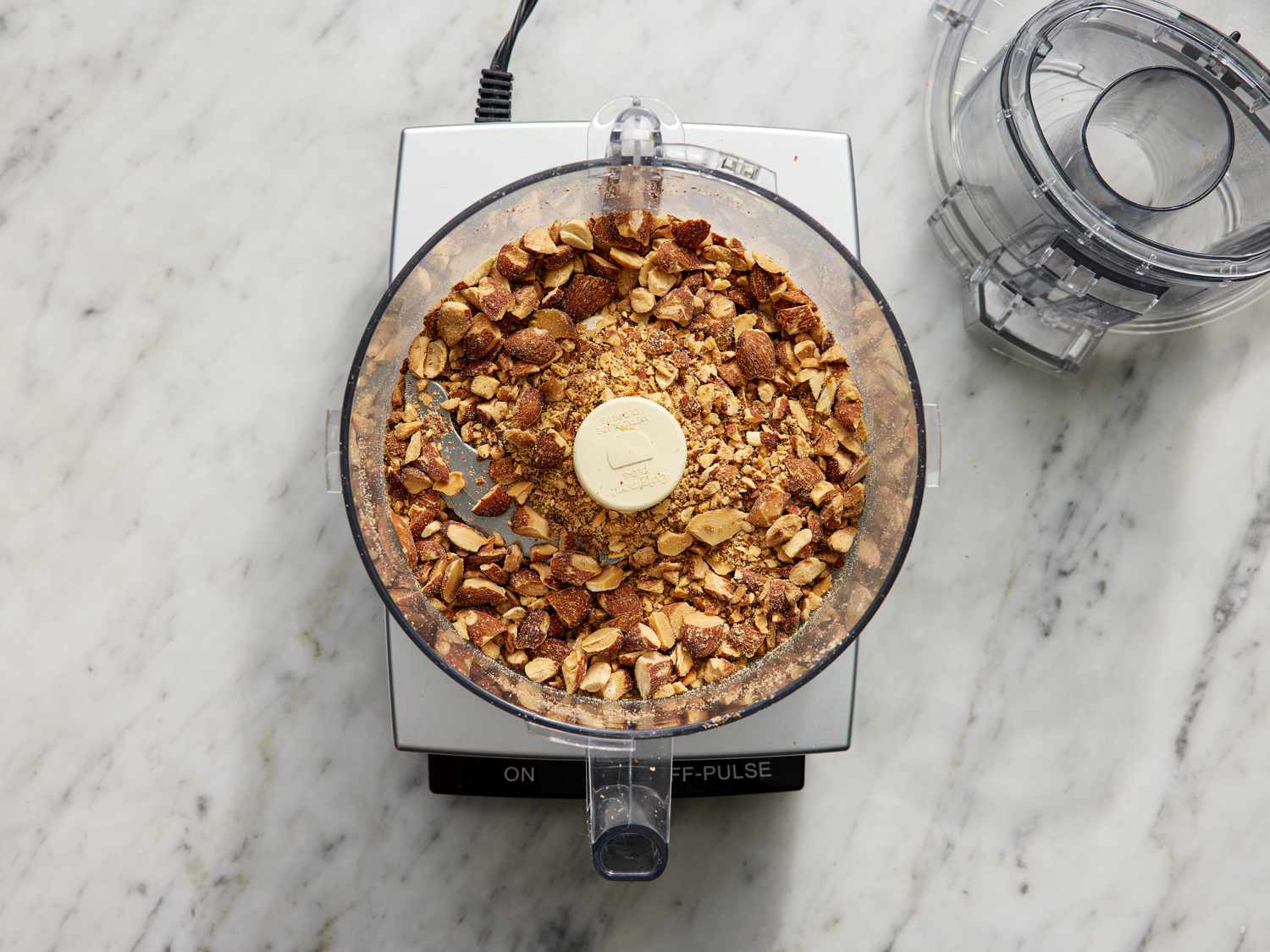 Overhead view of almonds roughly chopped in food processor