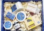 An assortment of gourmet cheese and other food items arranged in a gift box