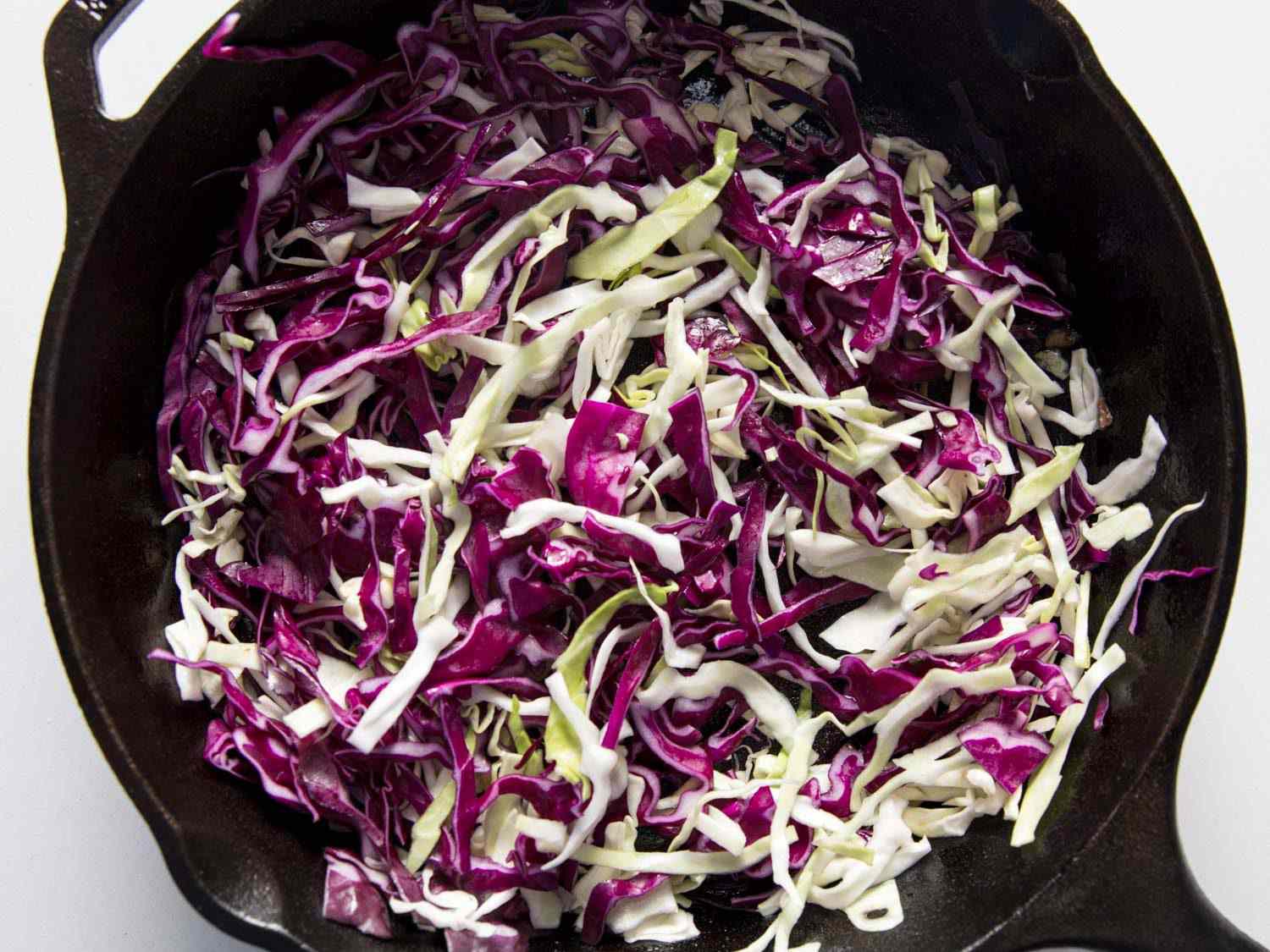 Cabbage slaw cooking in cast iron skillet