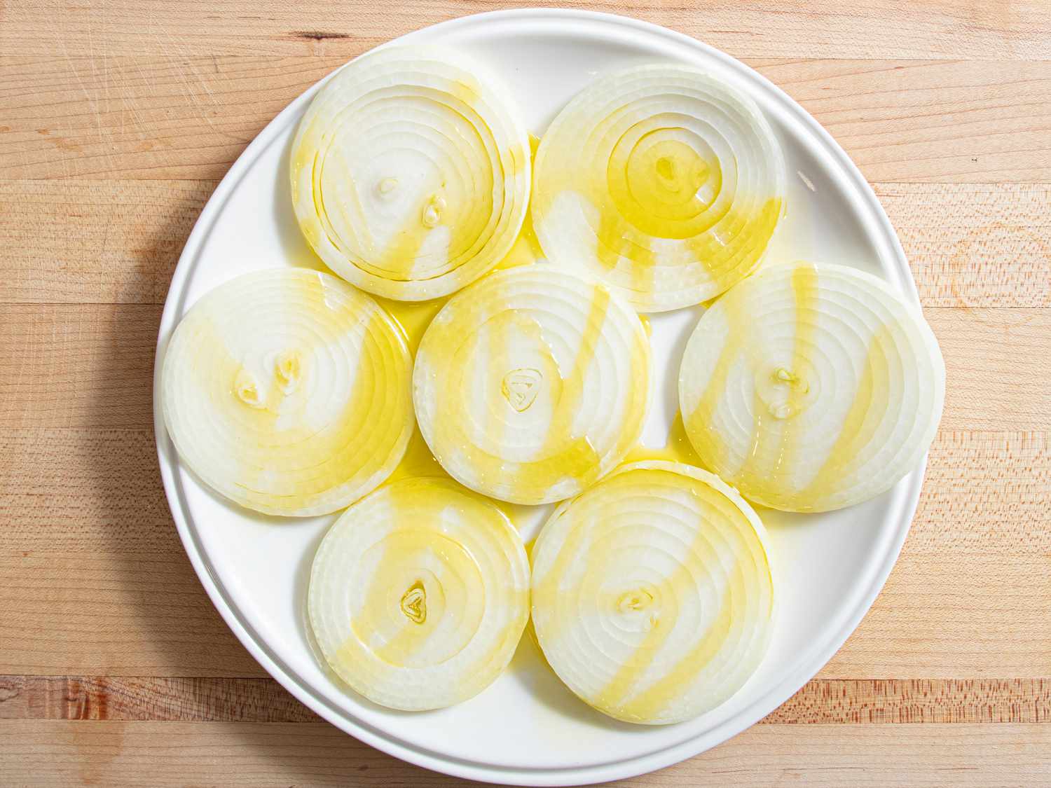 Sliced onions arranged on a white plate