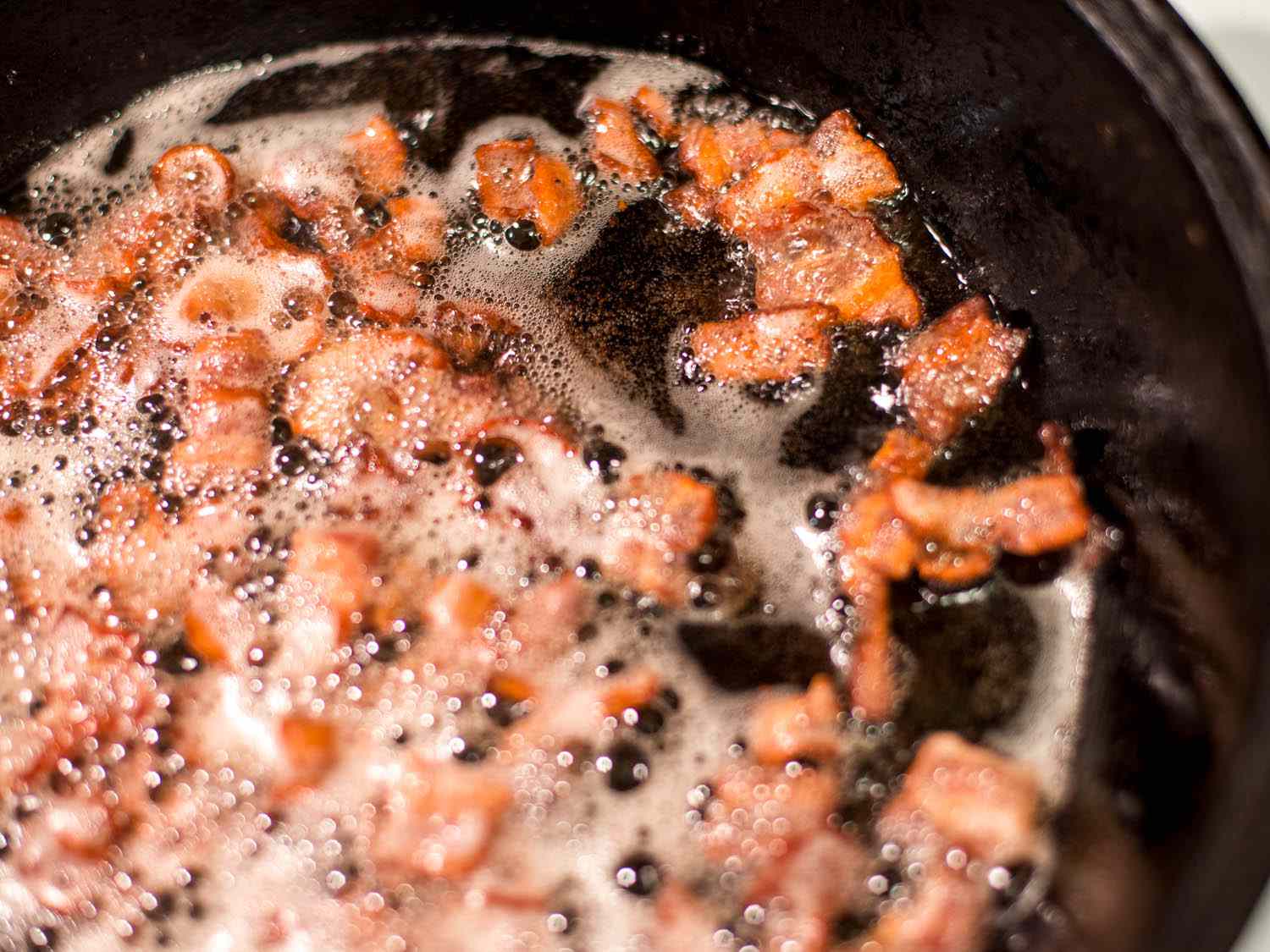 Crisping bacon bits in cast-iron skillet.