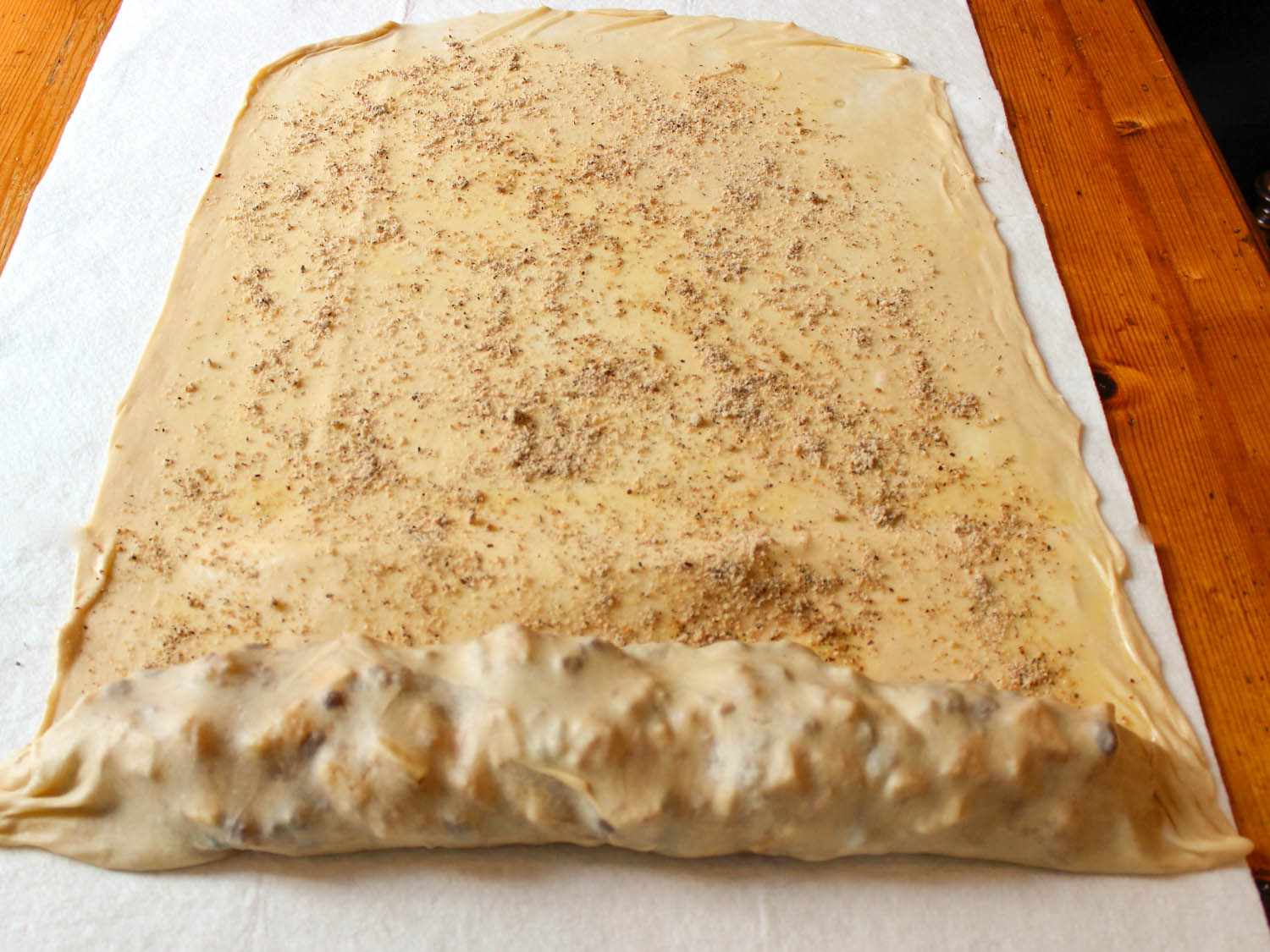 The dough has been draped over the filling and the strudel is ready to roll up.