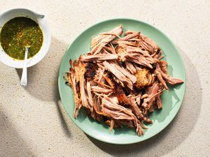 Overhead view of Cuban-Style Roast Pork Shoulder With Mojo, served on a seafoam colored platwe.