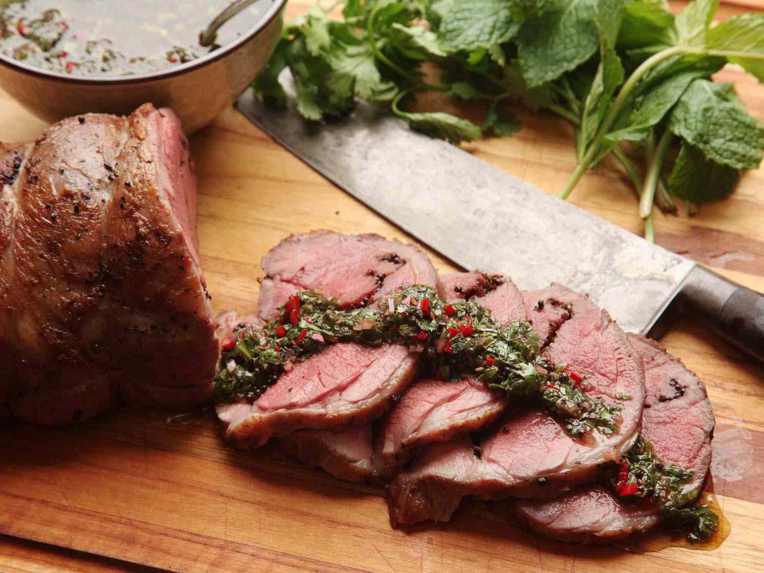 Sous vide lamb leg sliced up topped with chimichurri sauce 