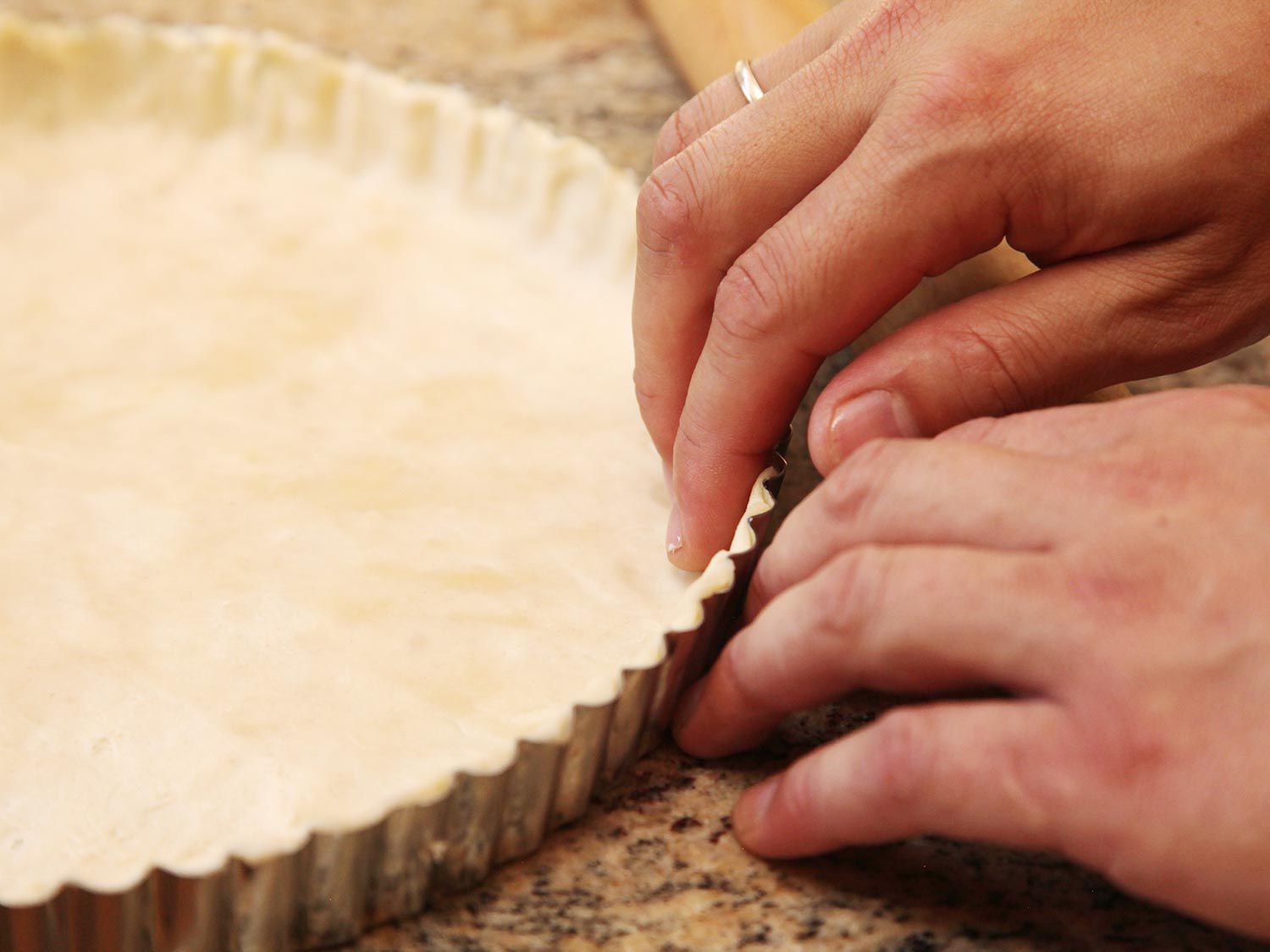 Author presses pie dough into corners of tart pan.