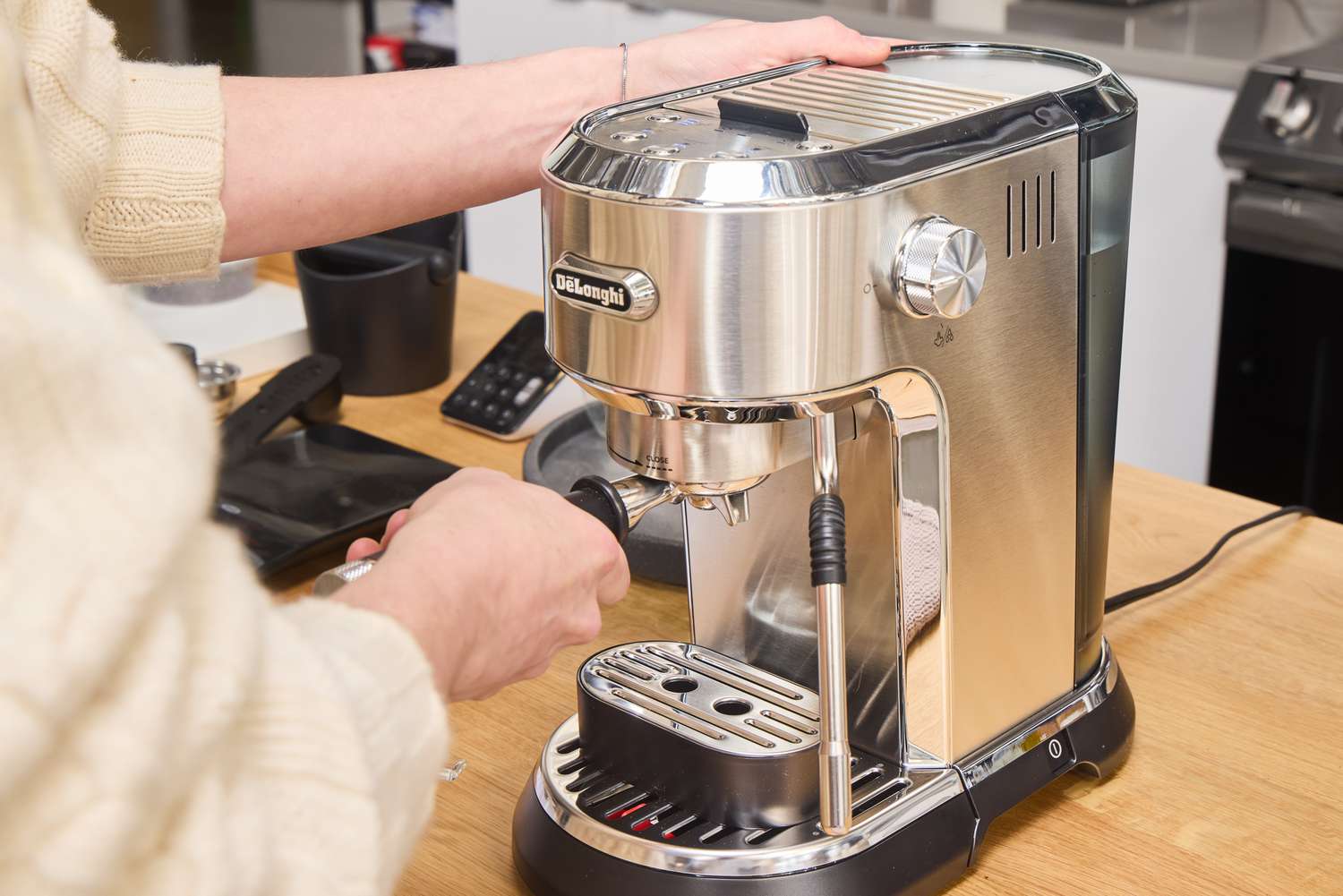 A person makes an espresso using the De'Longhi EC900M Dedica Maestro Espresso Machine