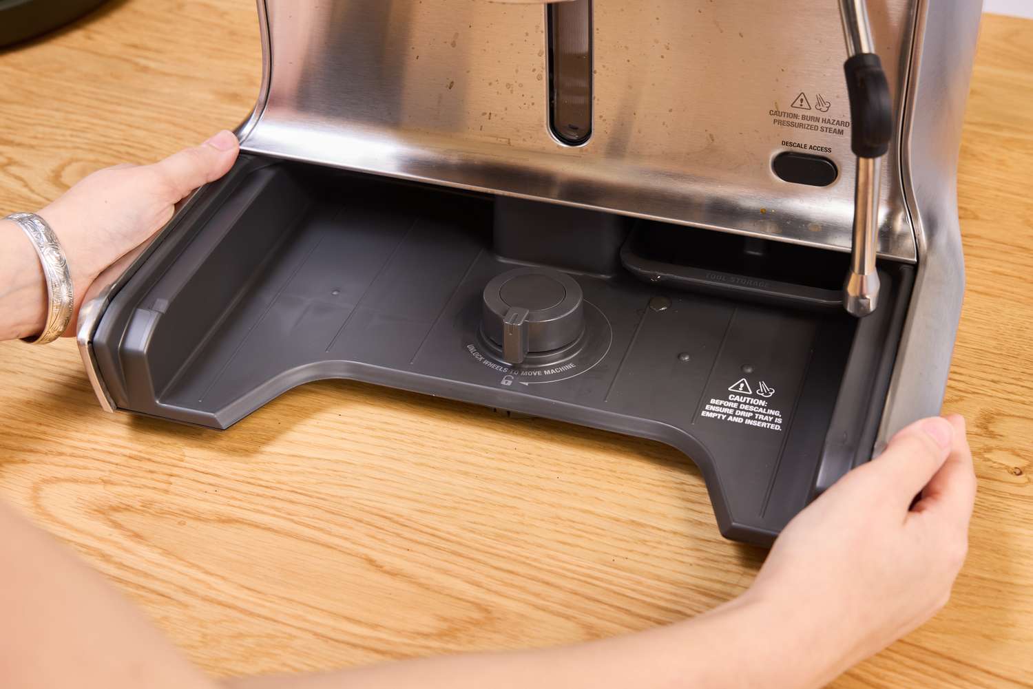 A person removes parts of the Breville BES920XL Dual Boiler Espresso Machine