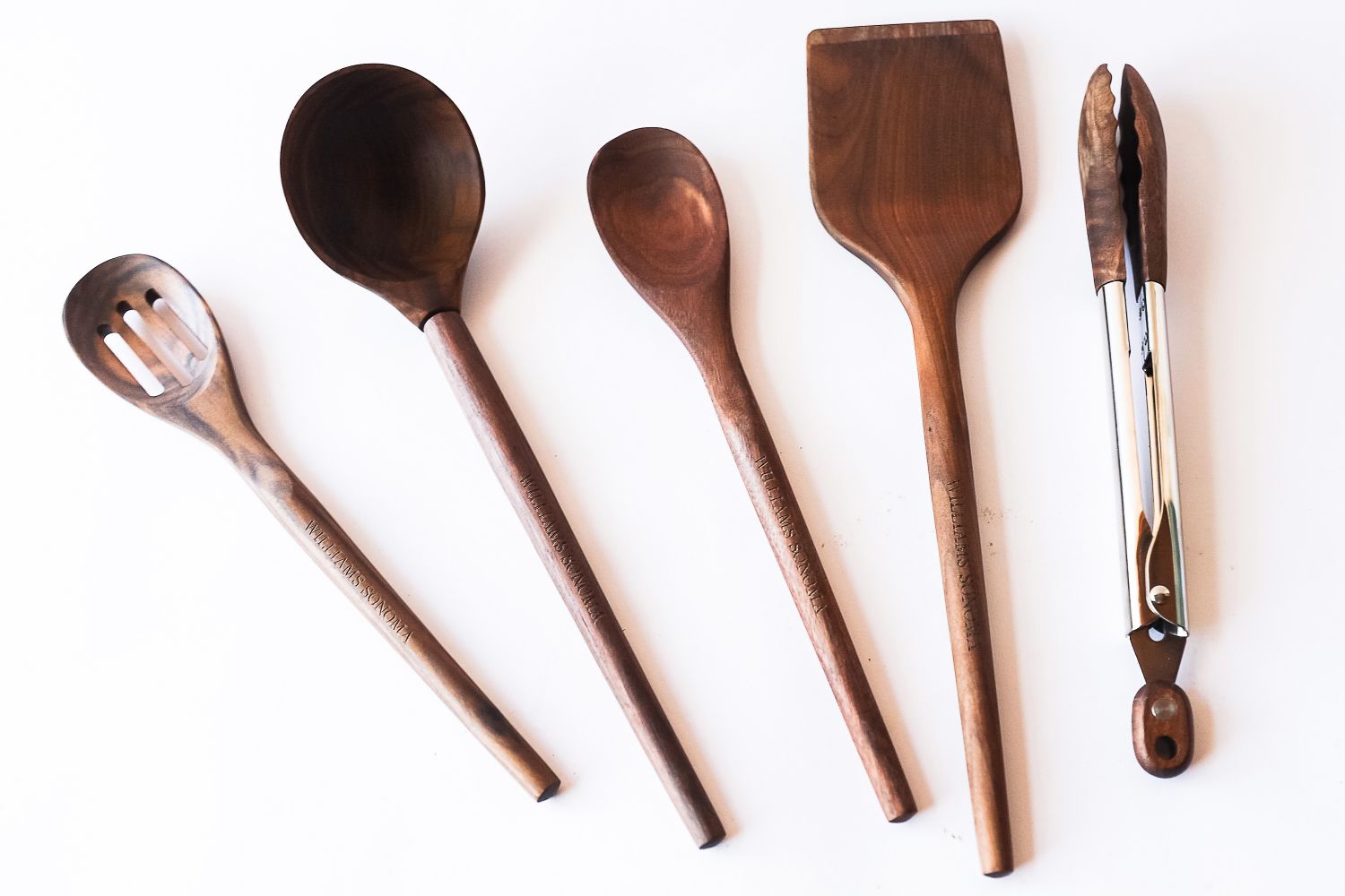 A set of wooden cooking utensils including spoons spatula and tongs