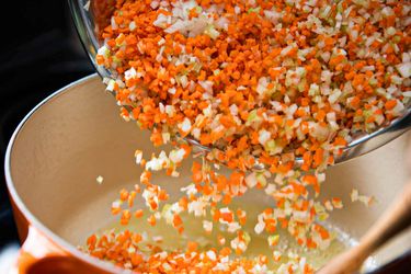 Diced vegetables being added to a pot
