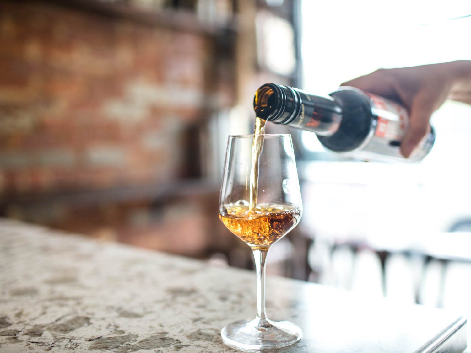An amber-colored Oloroso sherry being poured into a wineglass