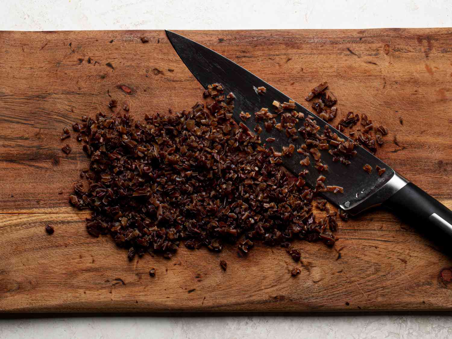 Mushrooms finely diced on a wooden cutting board