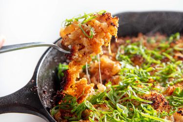 Cheese pull from forkful of cheesy kimchi skillet rice