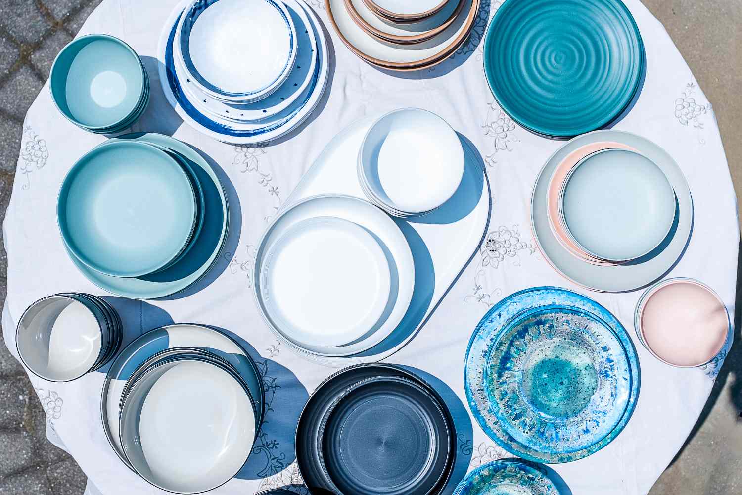 An overhead view of a table filled with blue and pink outdoor dinnerware sets