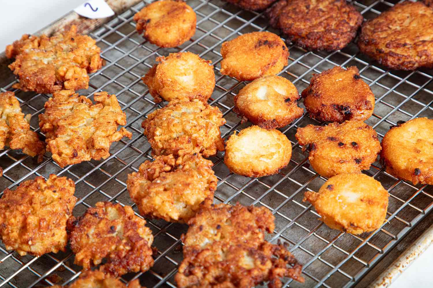 A variety of latkes on a cooling rack