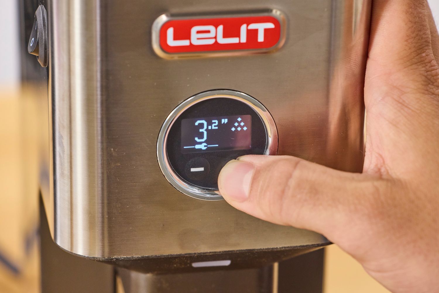 A person presses a button on the Lelit William Espresso Grinder