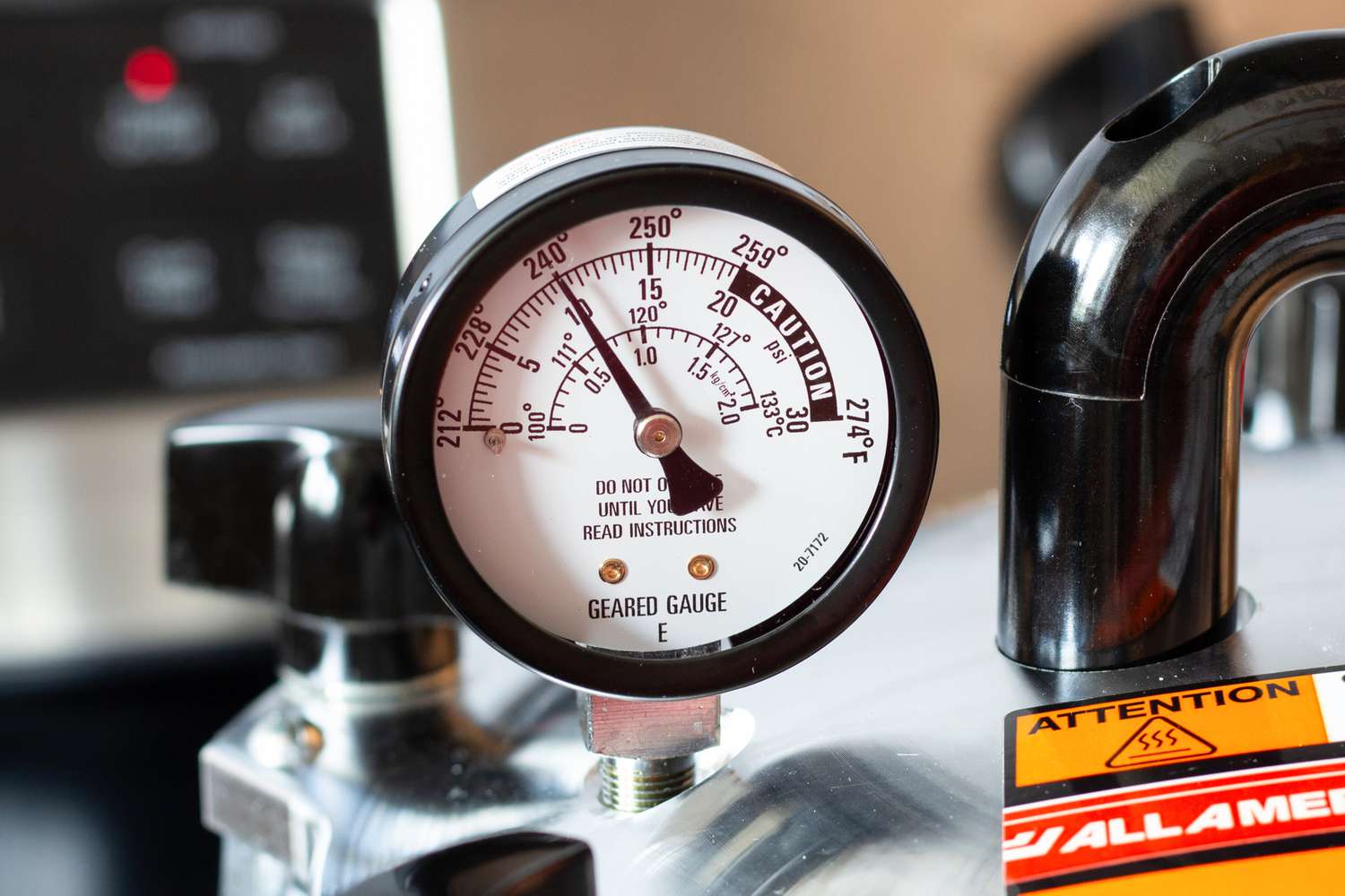 A pressure canner's gauge climbing to the 240°F mark.