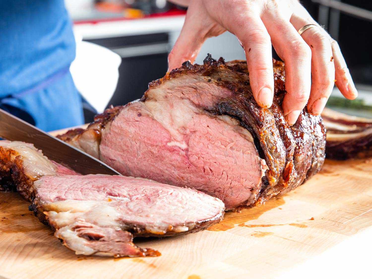 Slicing pieces of prime rib on a cutting board.