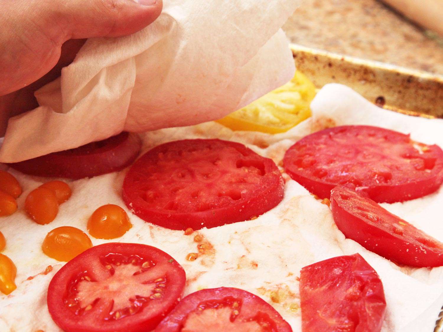Author blots tomato slices with a paper towel.