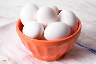 White eggs in an orange bowl.