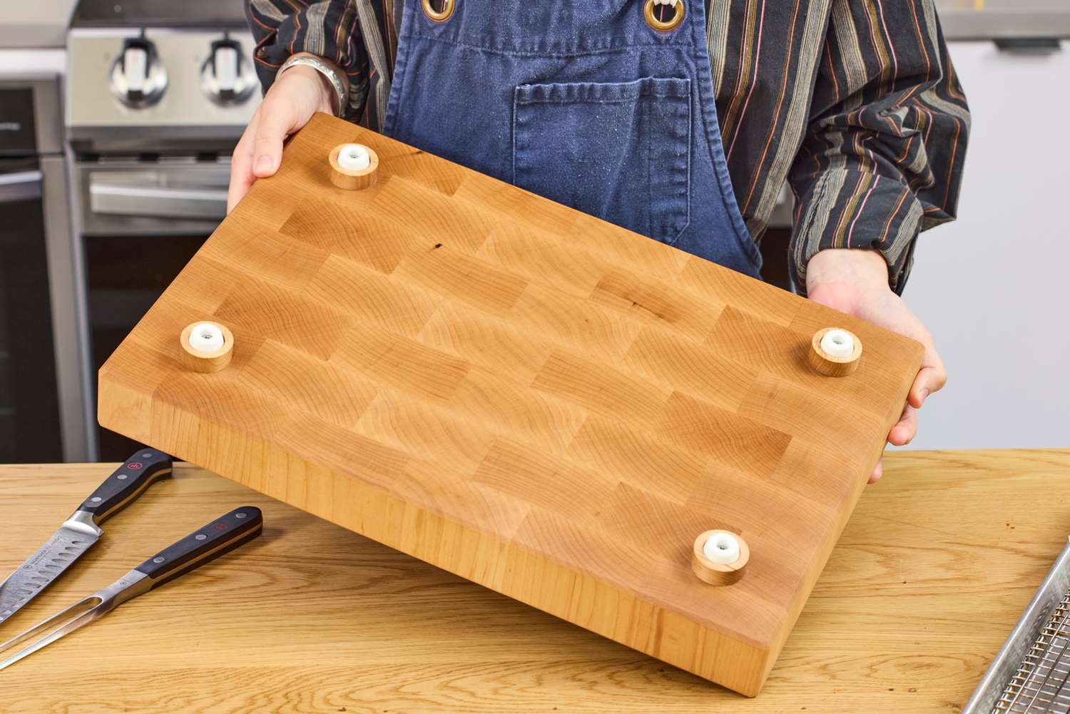 Person holding a Boardsmith Maple End-Grain Cutting Board with feet attached