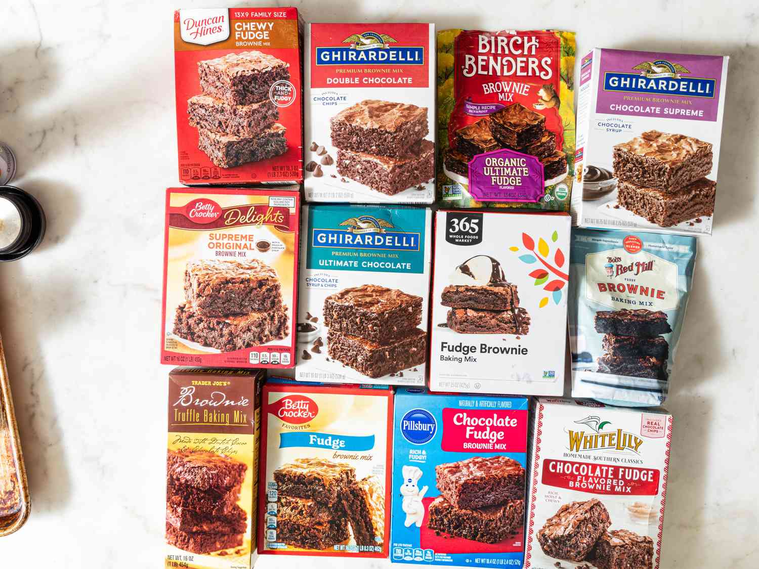 Many different boxes of Brownie mix moxes lined up together on a white surface 