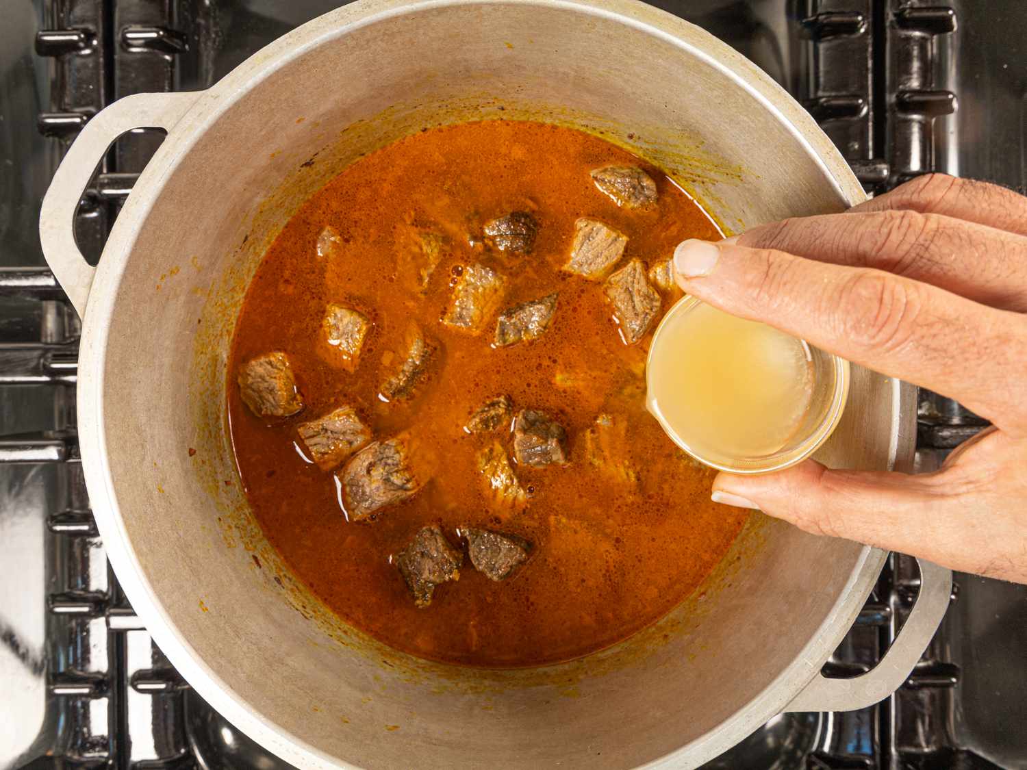 Overhead view of adding lemon juice to pot