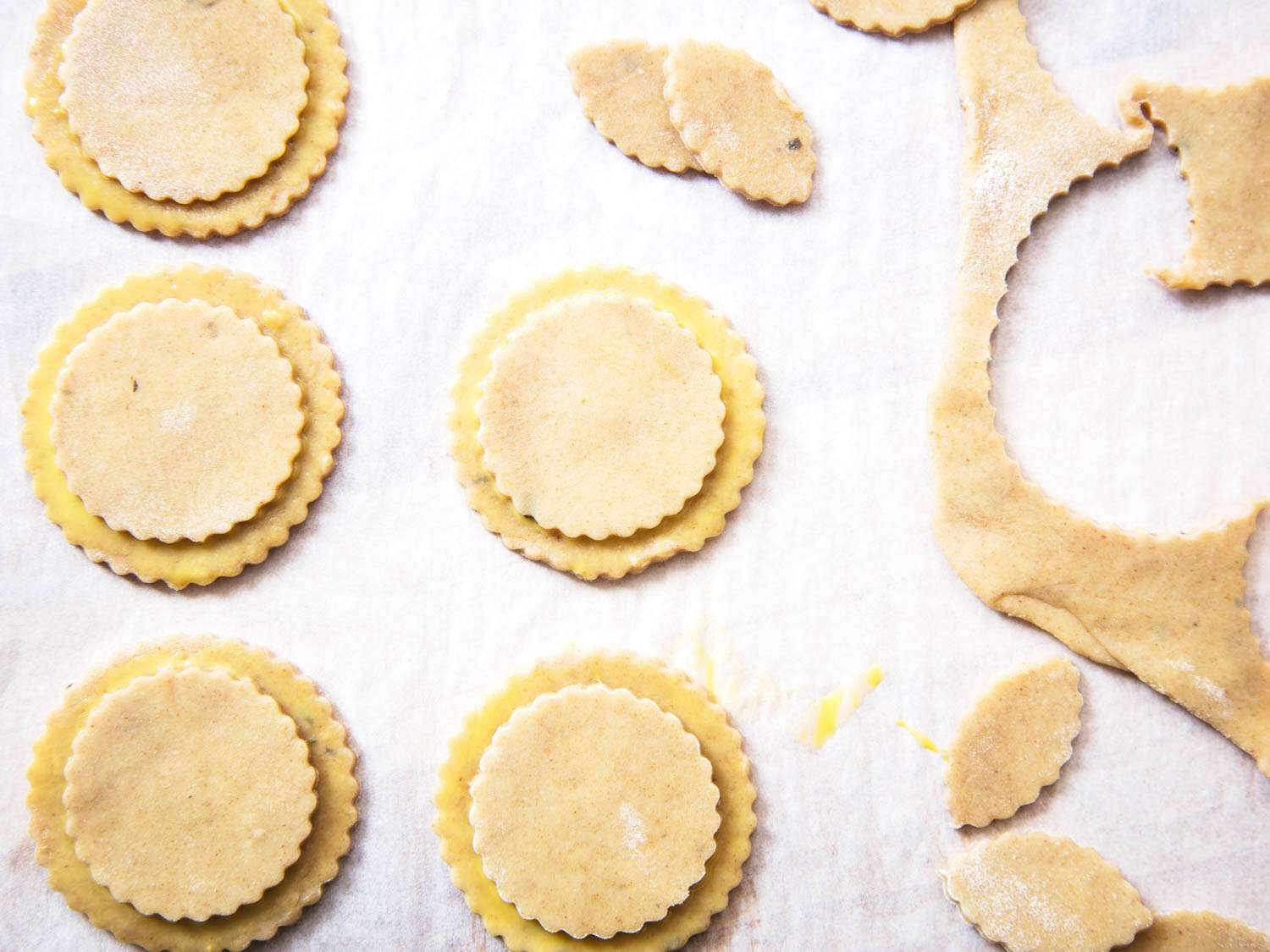 Overhead view of layered rounds of pastry set on parchment, ready to be used as découpage for a pâté en croûte.