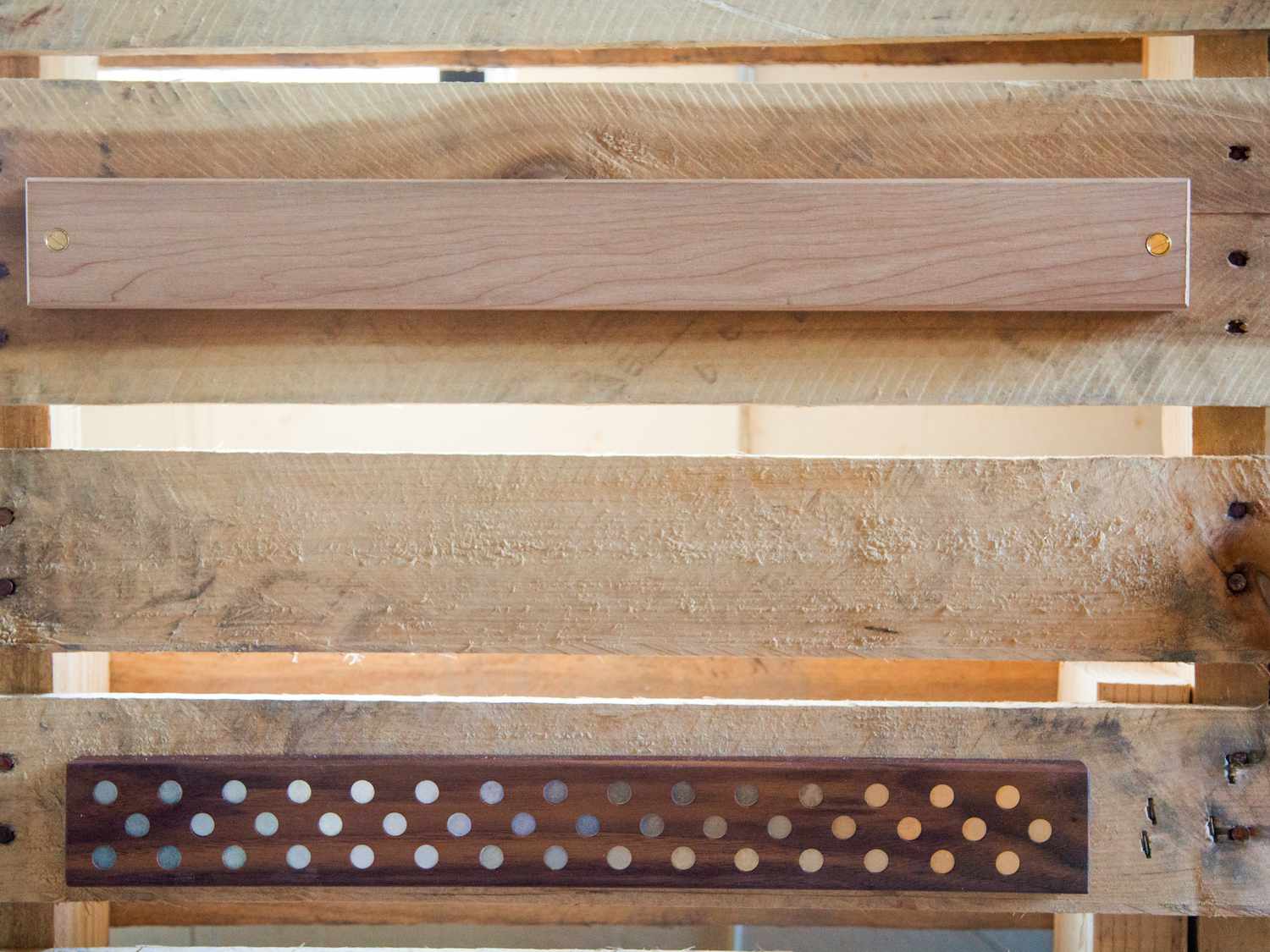 Two wooden magnetic knife holders screwed onto a wooden pallet