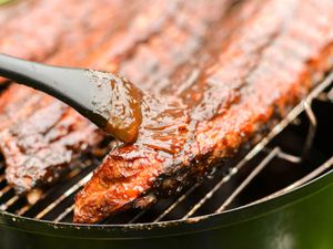 Balsamic barbecue sauce is used to glaze ribs as they cook on the grill.