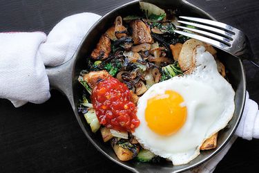 Overhead view of Spicy Potato, Bok Choy, and Shallot Hash, served in a cast iron skillet.